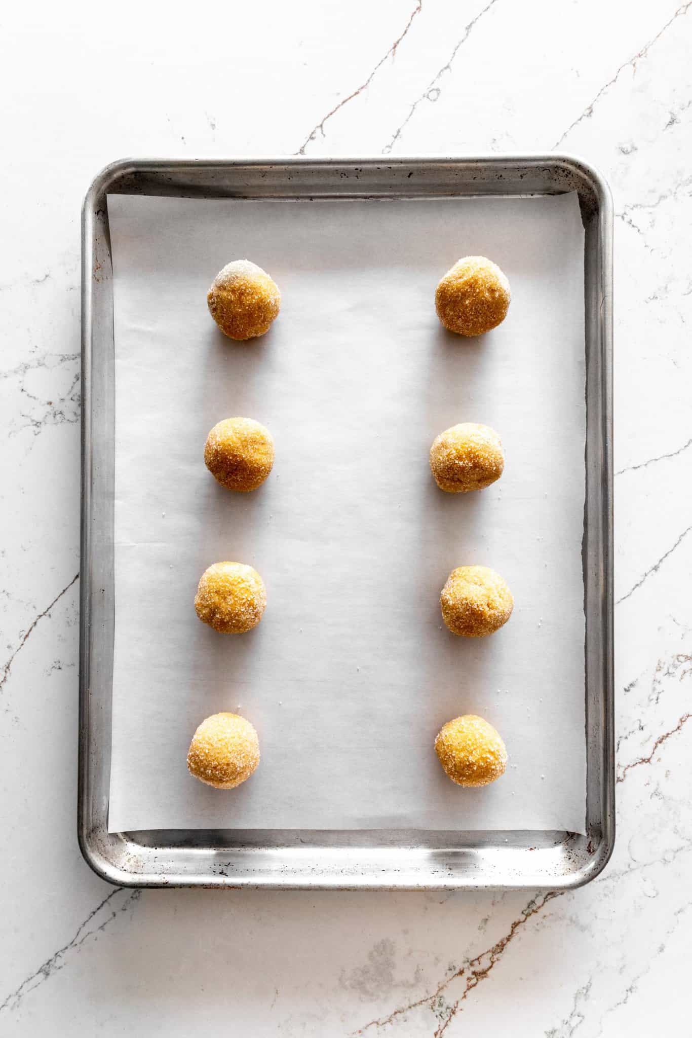 Unbaked pumpkin sugar cookies on a baking sheet.