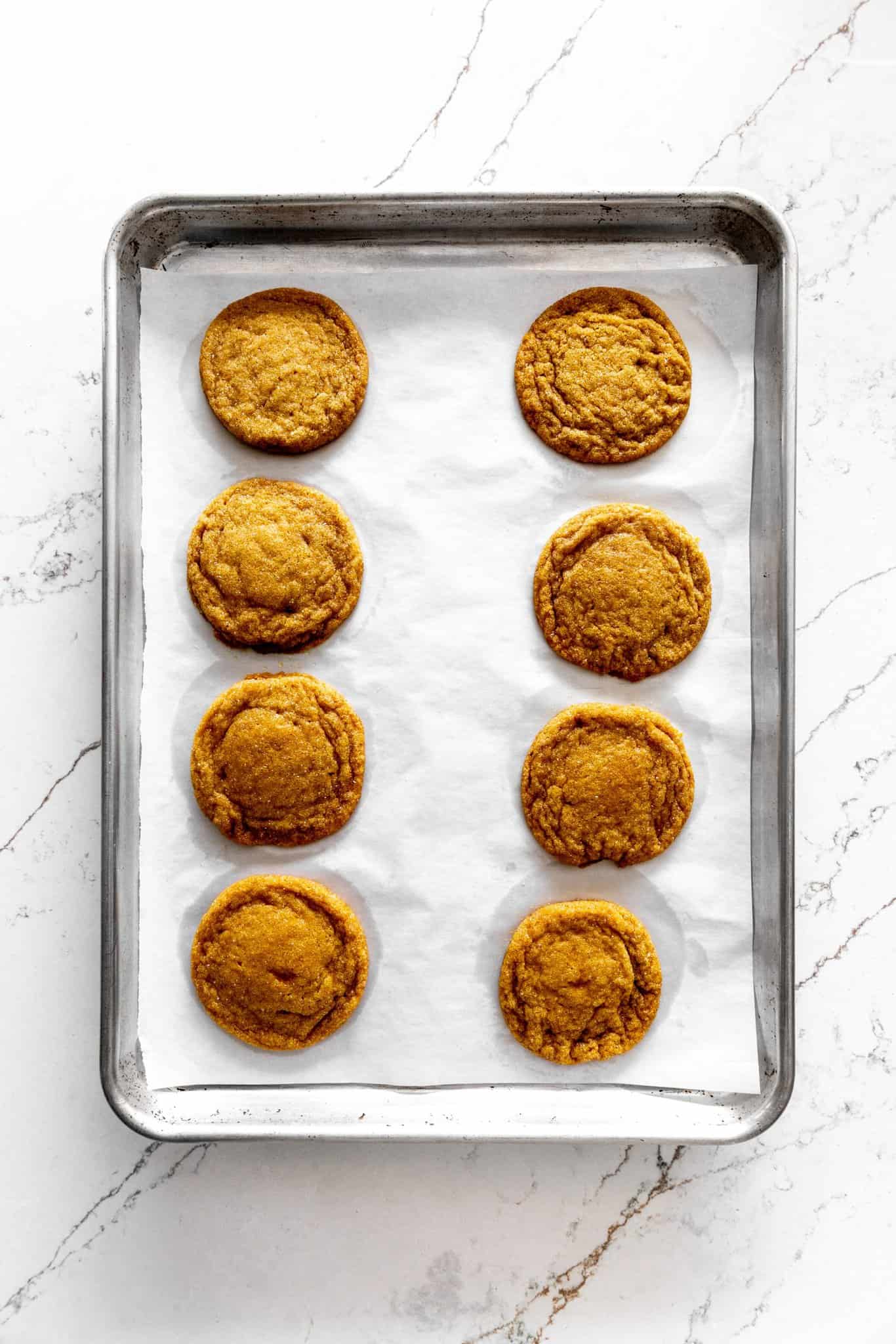 Baked pumpkin sugar cookies on a baking sheet.