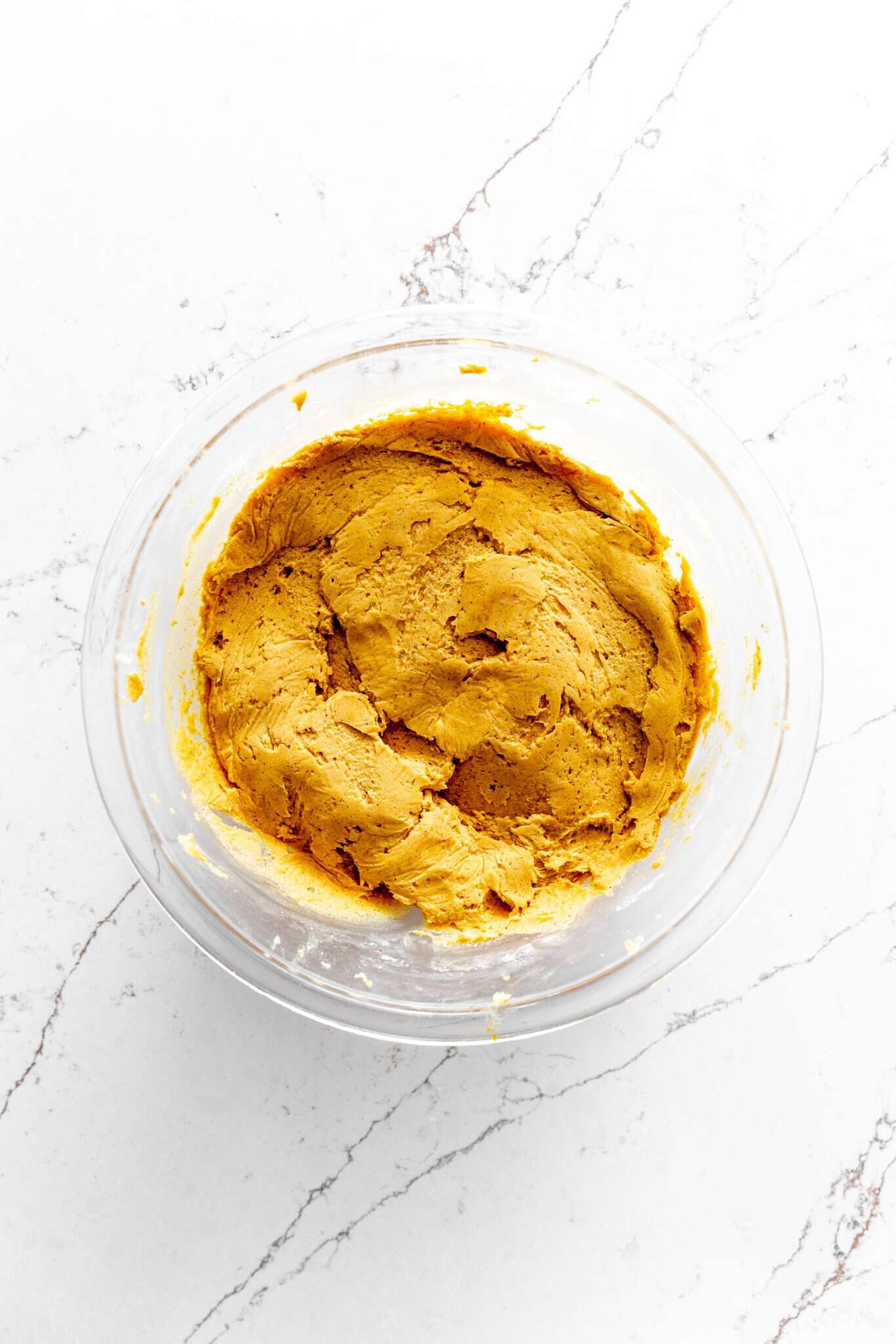 Glass bowl of pumpkin cookie dough.