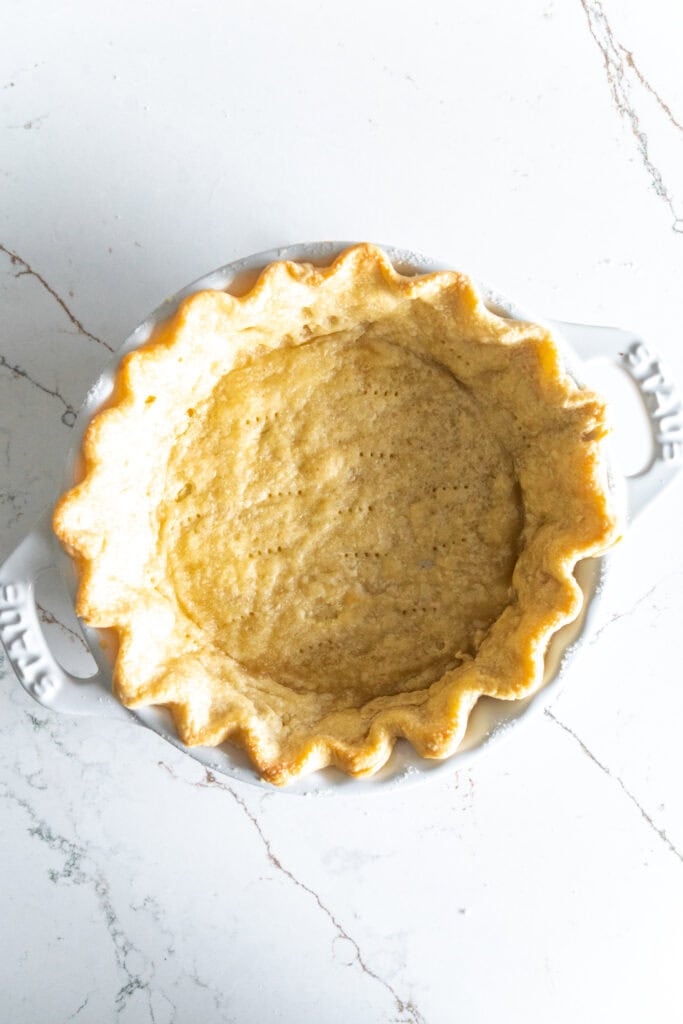 Baked piecrust in a white dish.