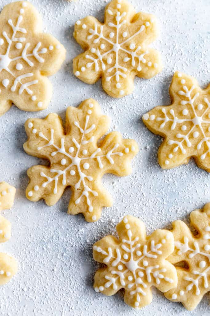 Frosted snowflake sugar cookies on a light blue background.