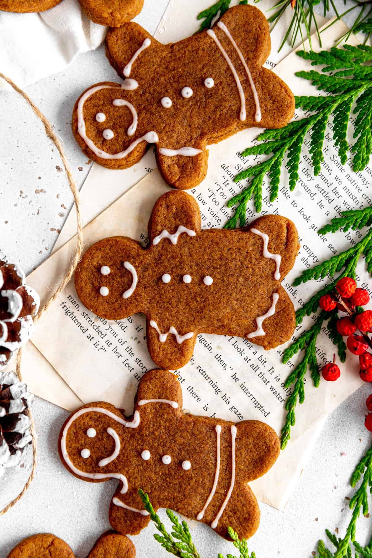 Gingerbread cookie people holding hands on a white surface.