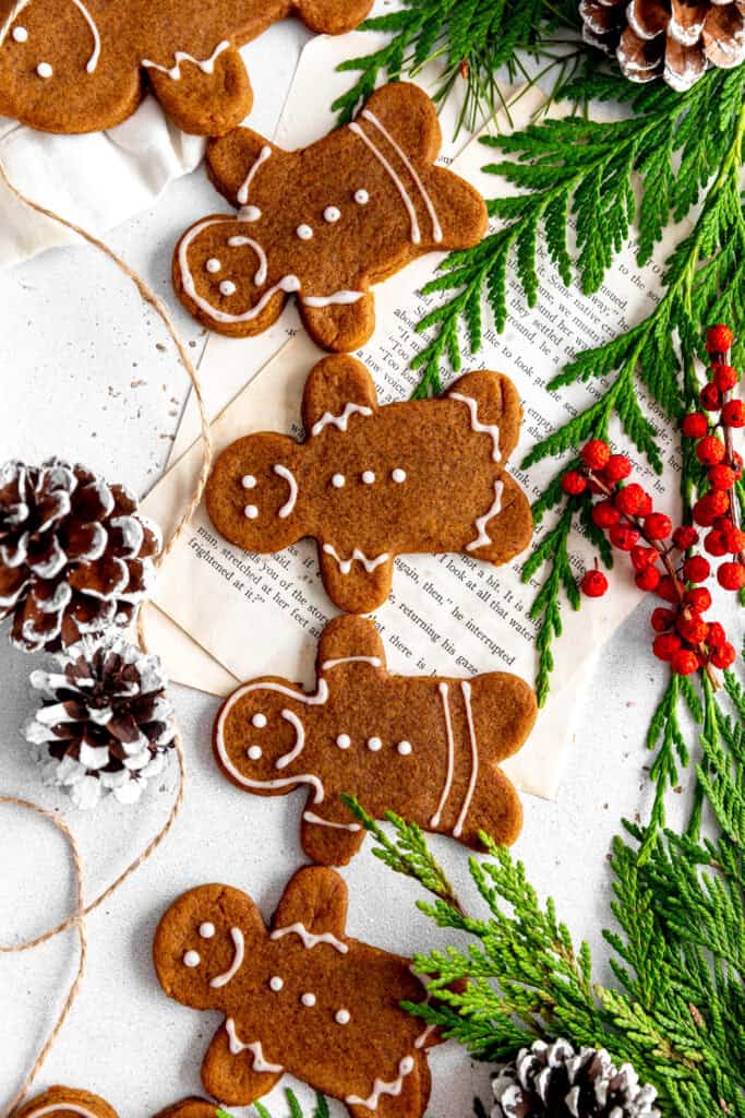 Gingerbread cookie people holding hands on a white surface.