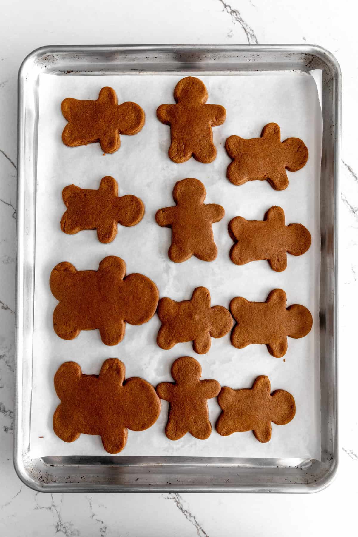 Baked gingerbread men on a baking sheet.