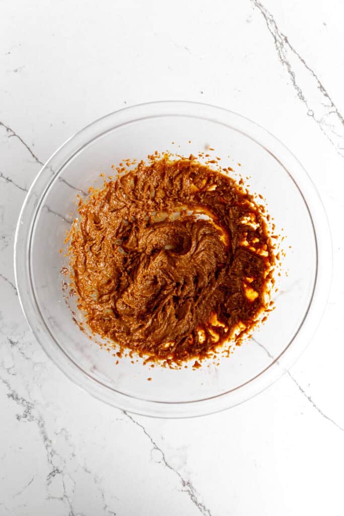 Creamed butter, sugar and molasses in a glass bowl.