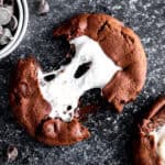 Hot chocolate cookie being pulled apart with the marshmallow stretching between halves.