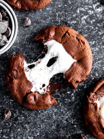 Hot chocolate cookie being pulled apart with the marshmallow stretching between halves.