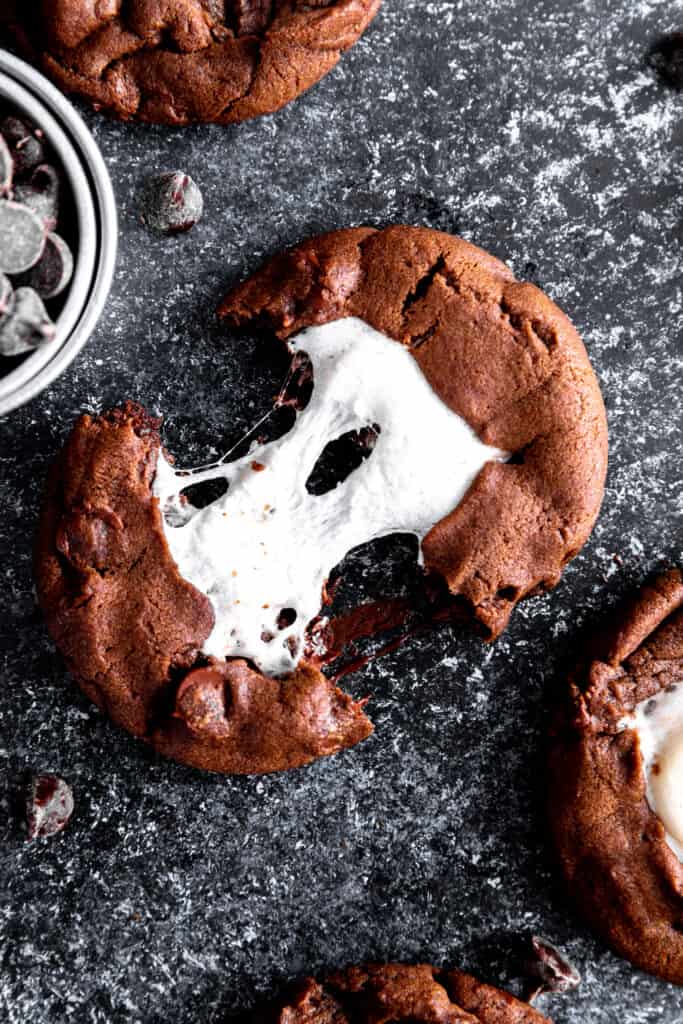 Hot chocolate cookie being pulled apart with the marshmallow stretching between halves.