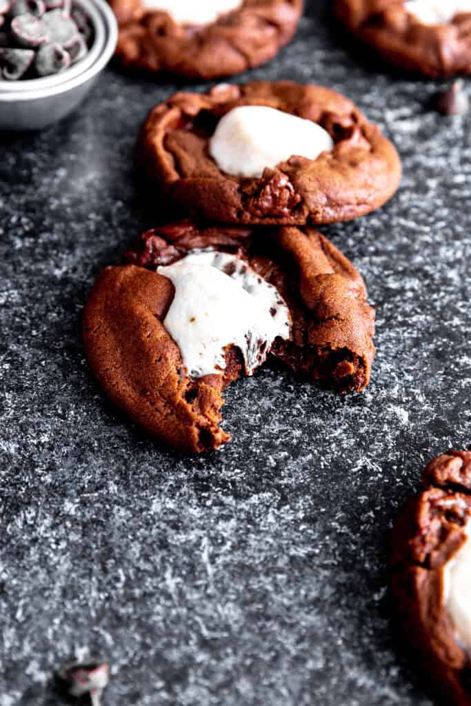 Hot chocolate cookie with a bite taken out of it and a cup of chocolate chips.