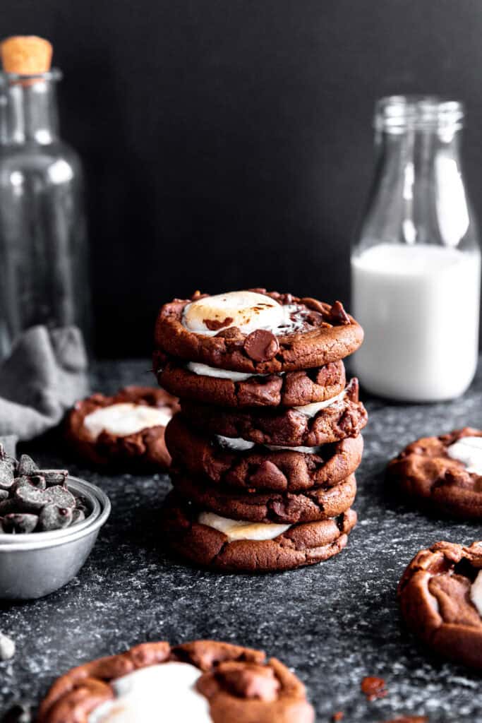 Stack of hot chocolate cookies and a jug of milk.