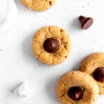 Peanut butter blossoms cookies, a glass of milk and additional candies.