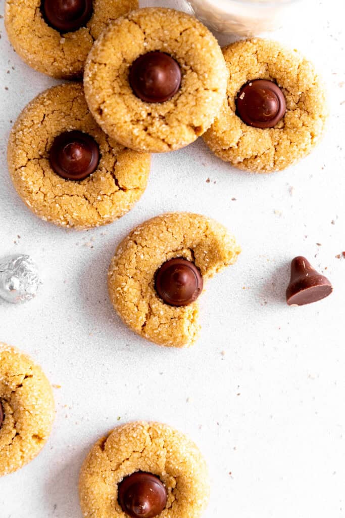 Peanut butter blossom with a bite taken out of it surrounded by more cookies.