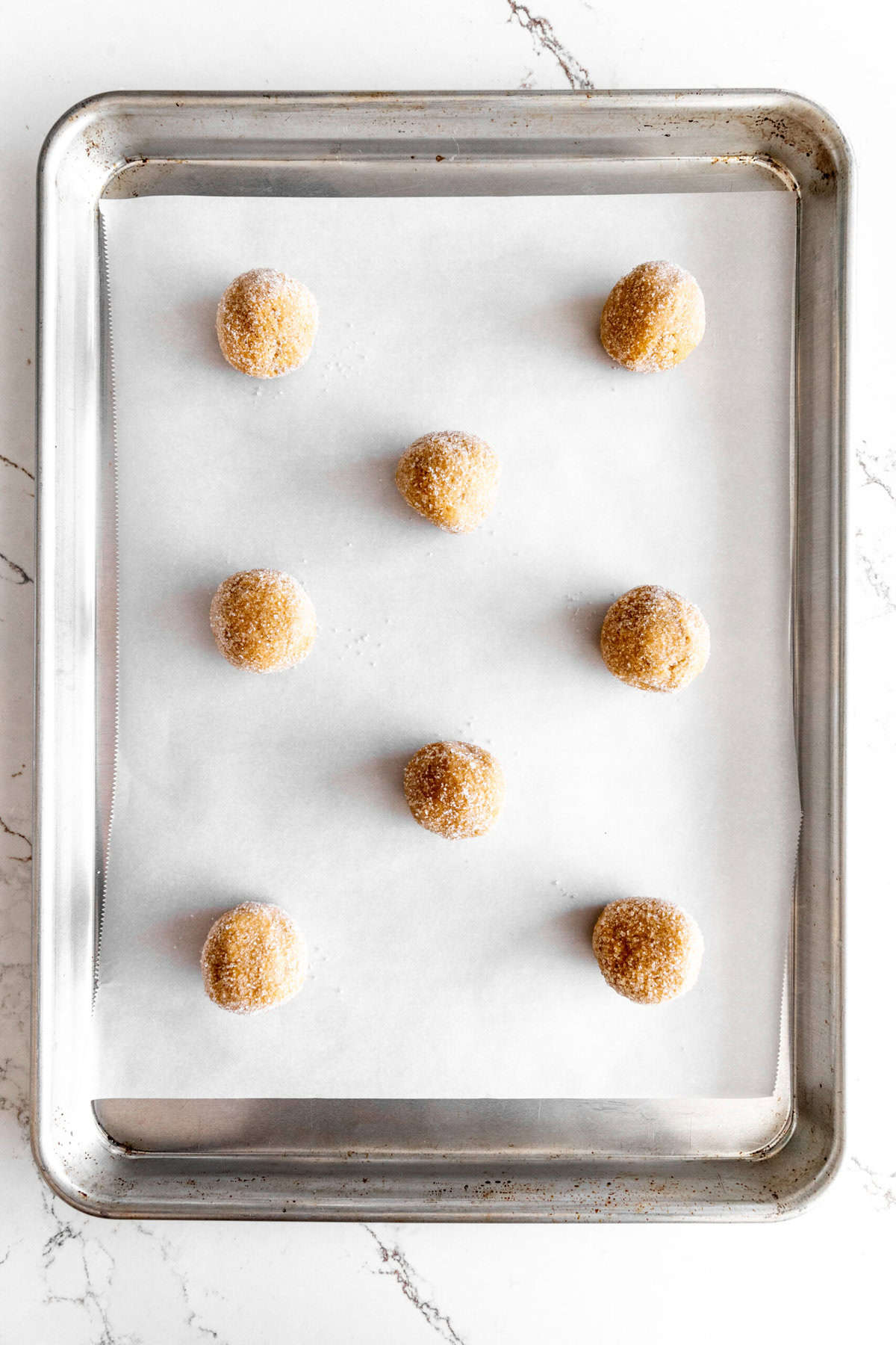 Unbaked peanut butter cookies on a baking sheet.