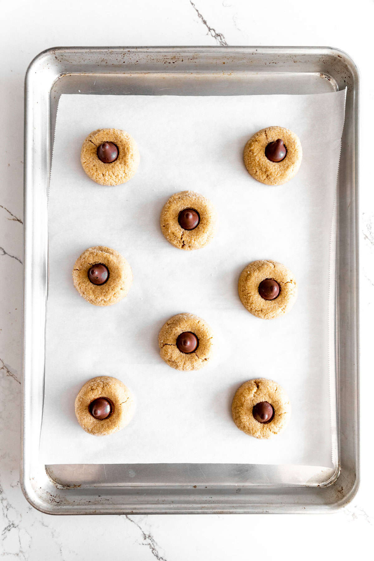 Peanut butter blossoms on a baking sheet.