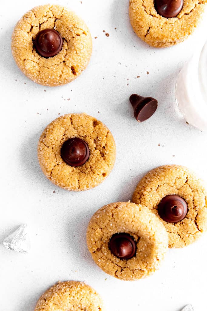 Peanut butter blossoms cookies, a glass of milk and additional candies.