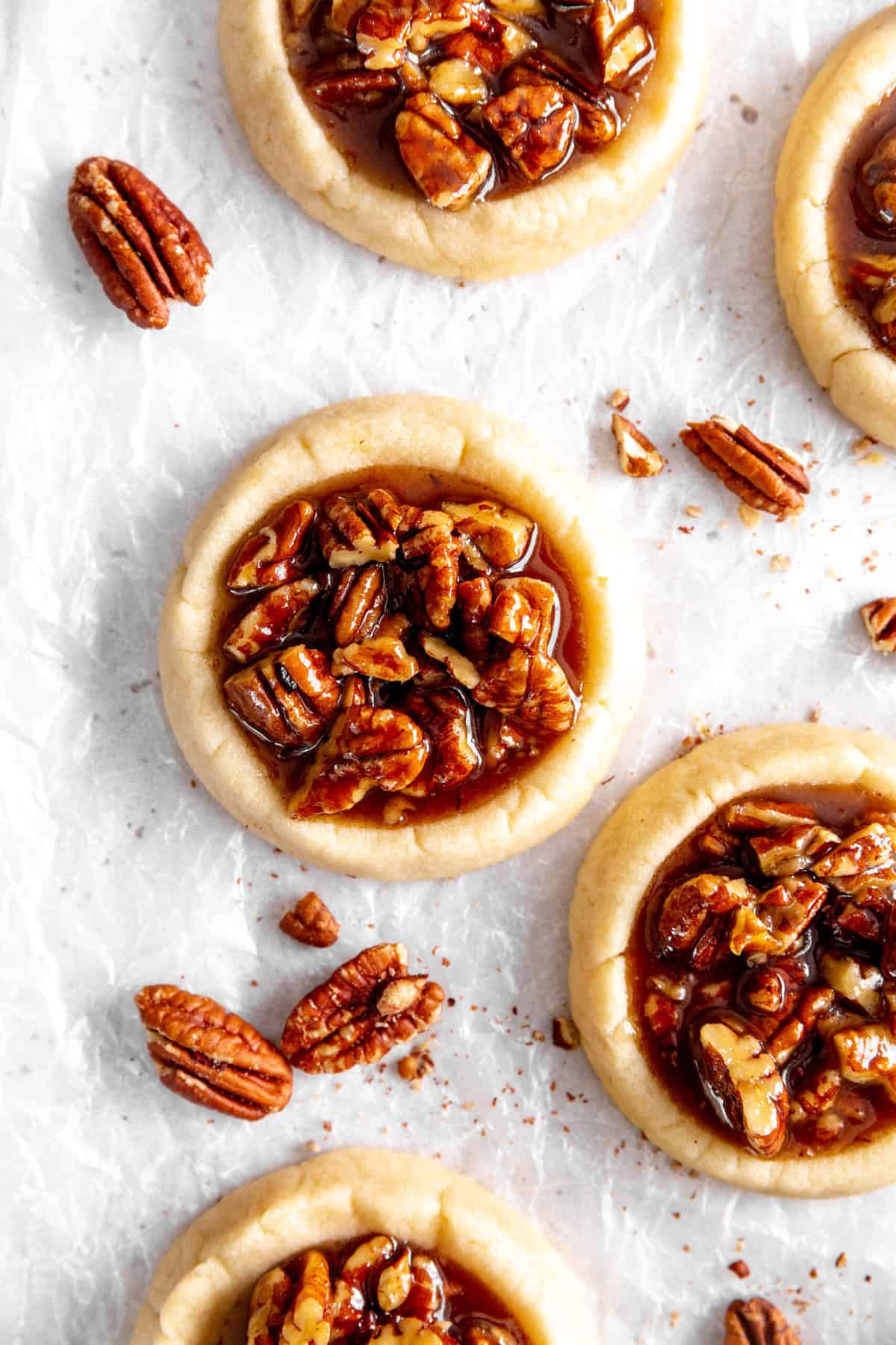 Vegan pecan pie cookies and scattered pecans.