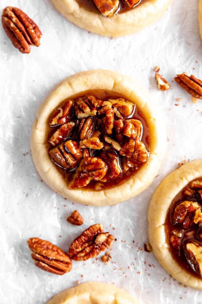 Vegan pecan pie cookies and scattered pecans.