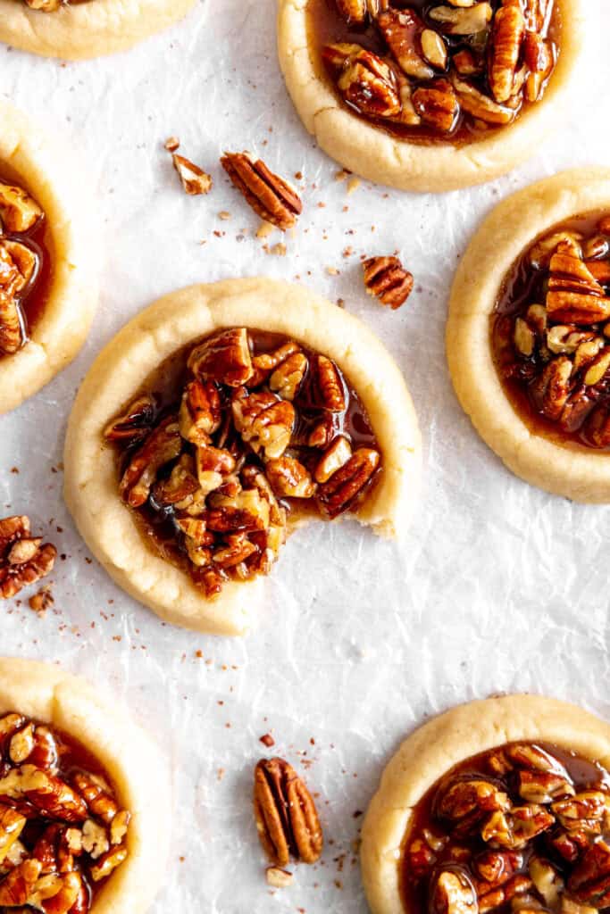 Vegan pecan pie cookie with a bite taken out of it and more cookies.