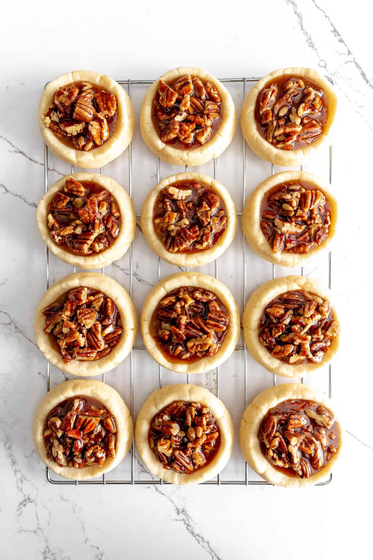 Assembled pecan pie cookies on a wire cooling rack.