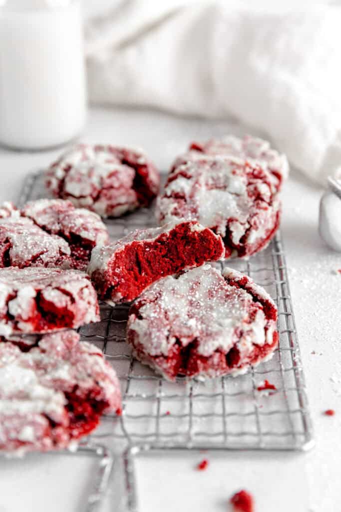 Red velvet crinkle cookie with a bite taken out of it propped up on another cookie.