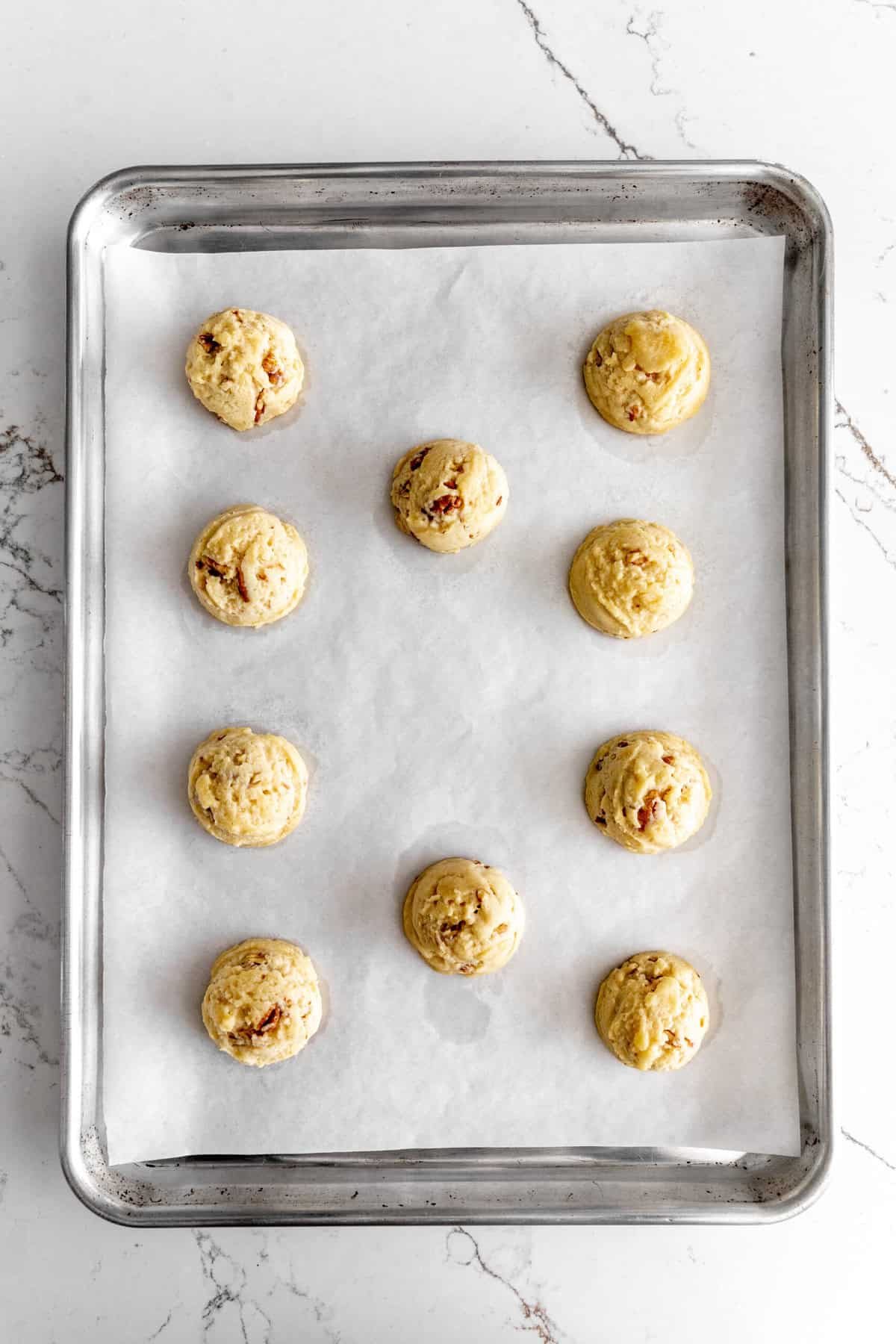 Baked snowball cookies on a baking sheet.