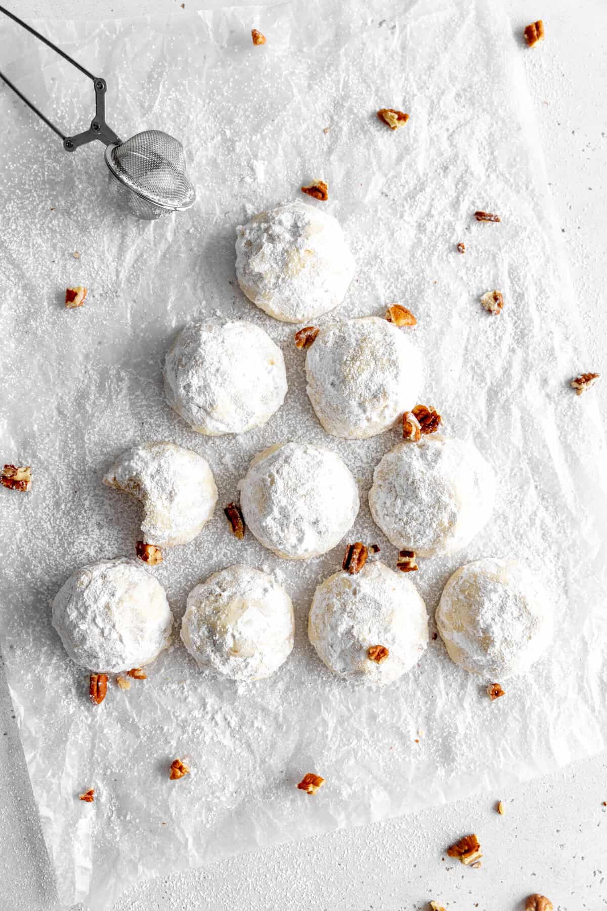 Snowball cookies arranged in the shape of a christmas tree.