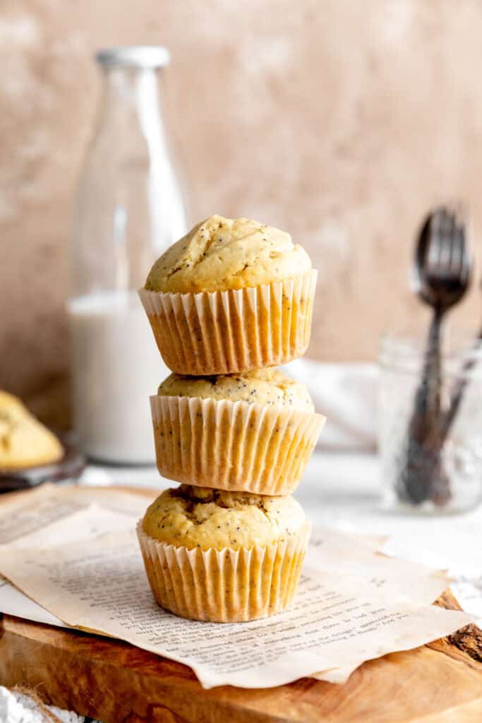 Stack of almond poppy seed muffins in front of a jug of milk.