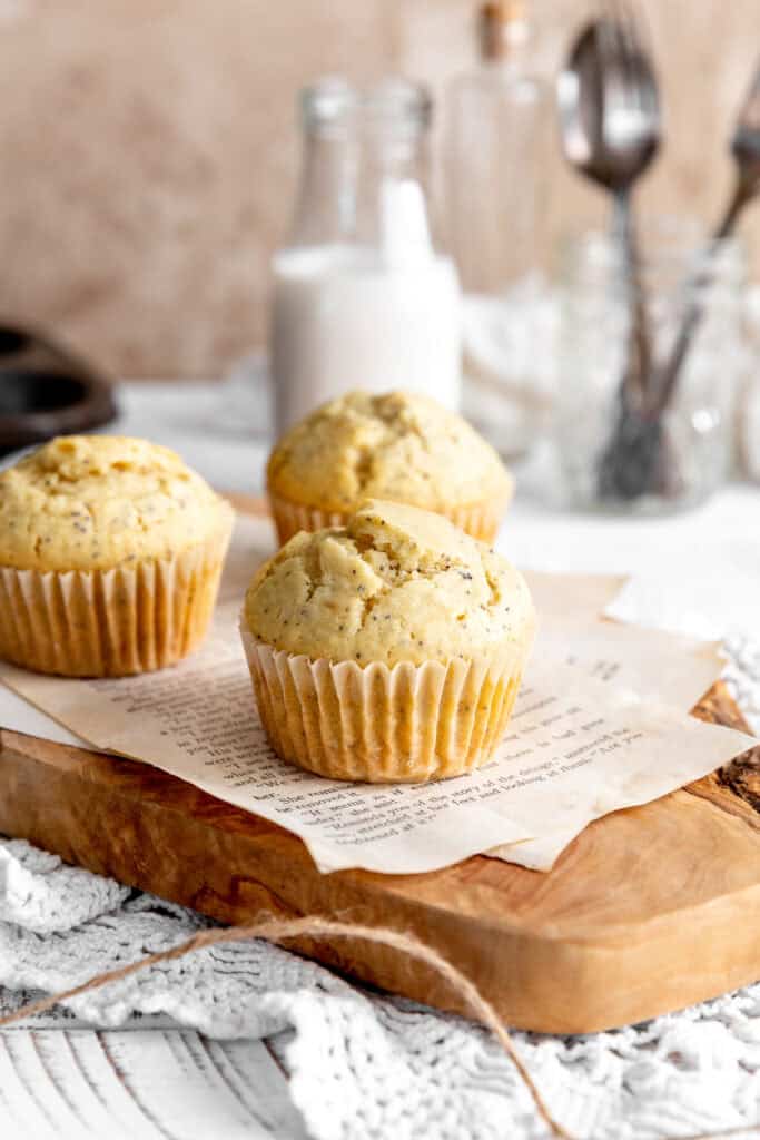 Almond poppy seed muffins, a jug of milk and a cup of forks.