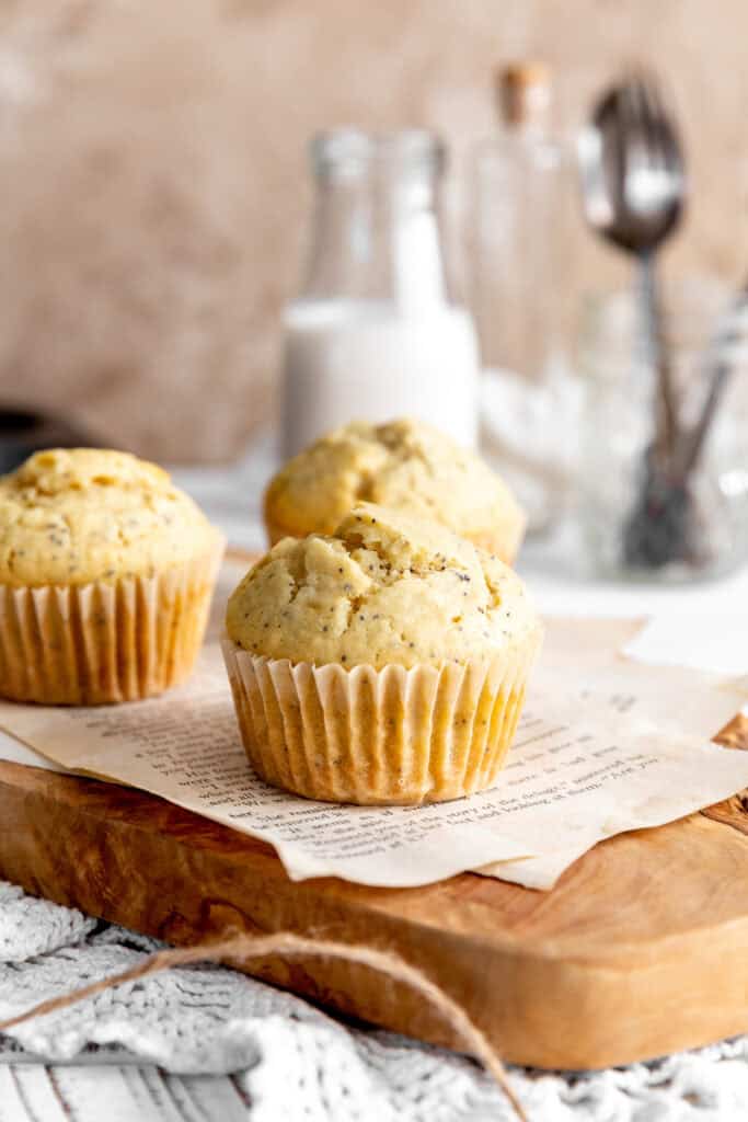 Almond poppy seed muffins, a jug of milk and a cup of forks.