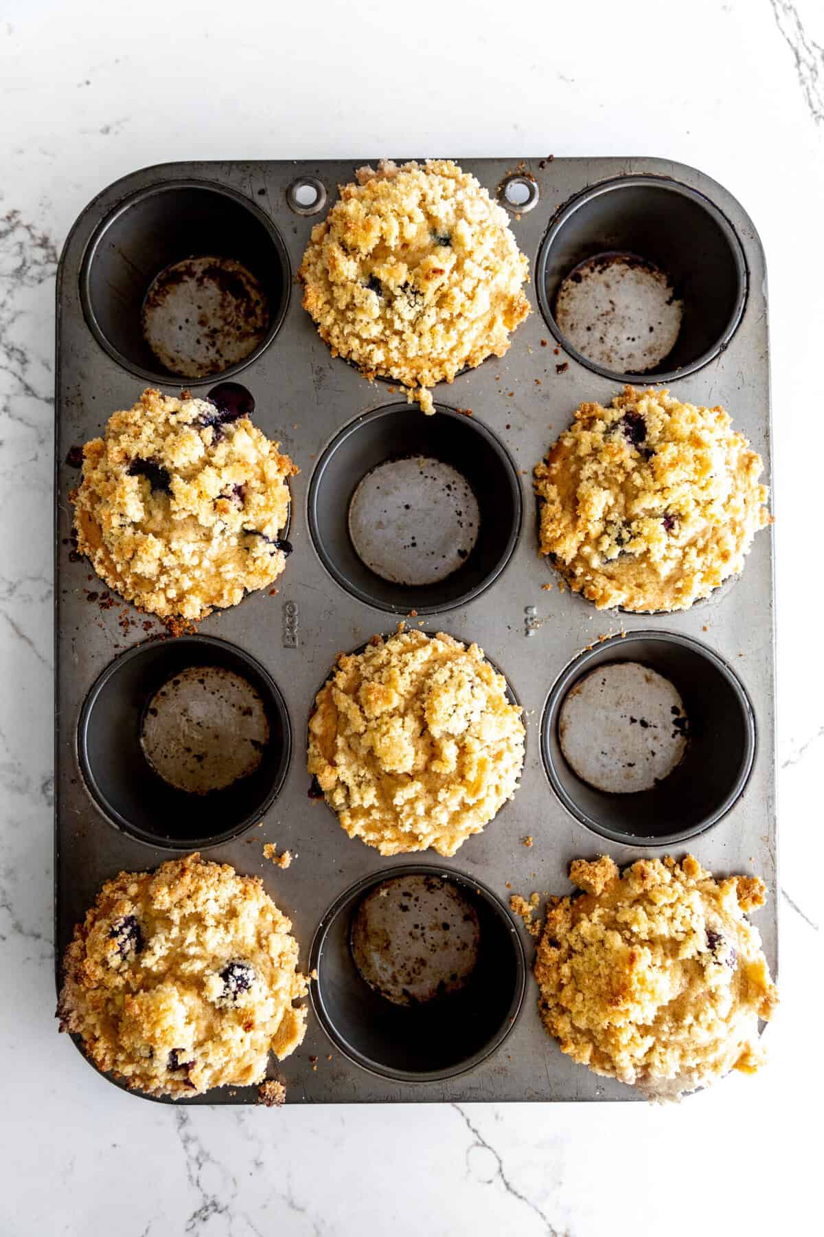 Baked blueberry muffins in a cupcake pan.