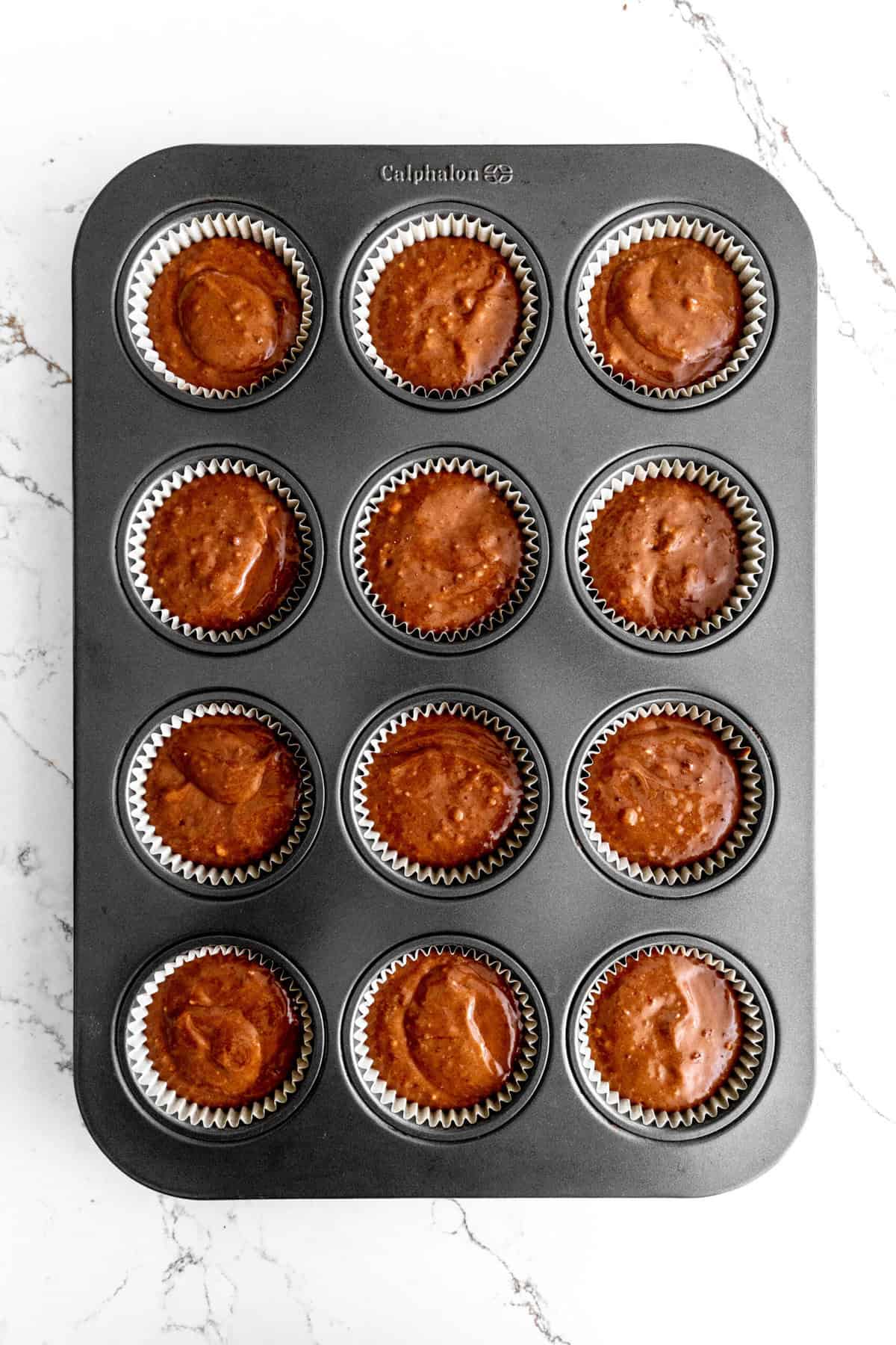 Unbaked chocolate cupcakes in a cupcake pan.