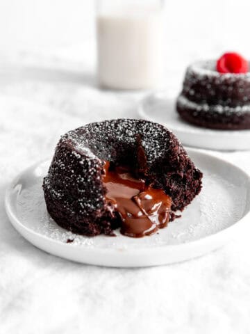 Chocolate lava cake oozing chocolate and a jug of milk.