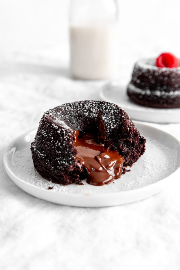 Chocolate lava cake oozing chocolate and a jug of milk.