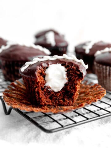 Hostess cupcake filled with vanilla creme with a bite taken out of it.