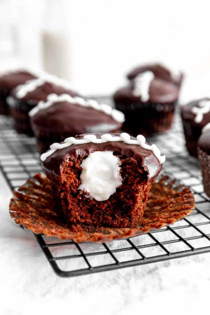 Hostess cupcake with a bite taken out of it sitting on its own wrapper.