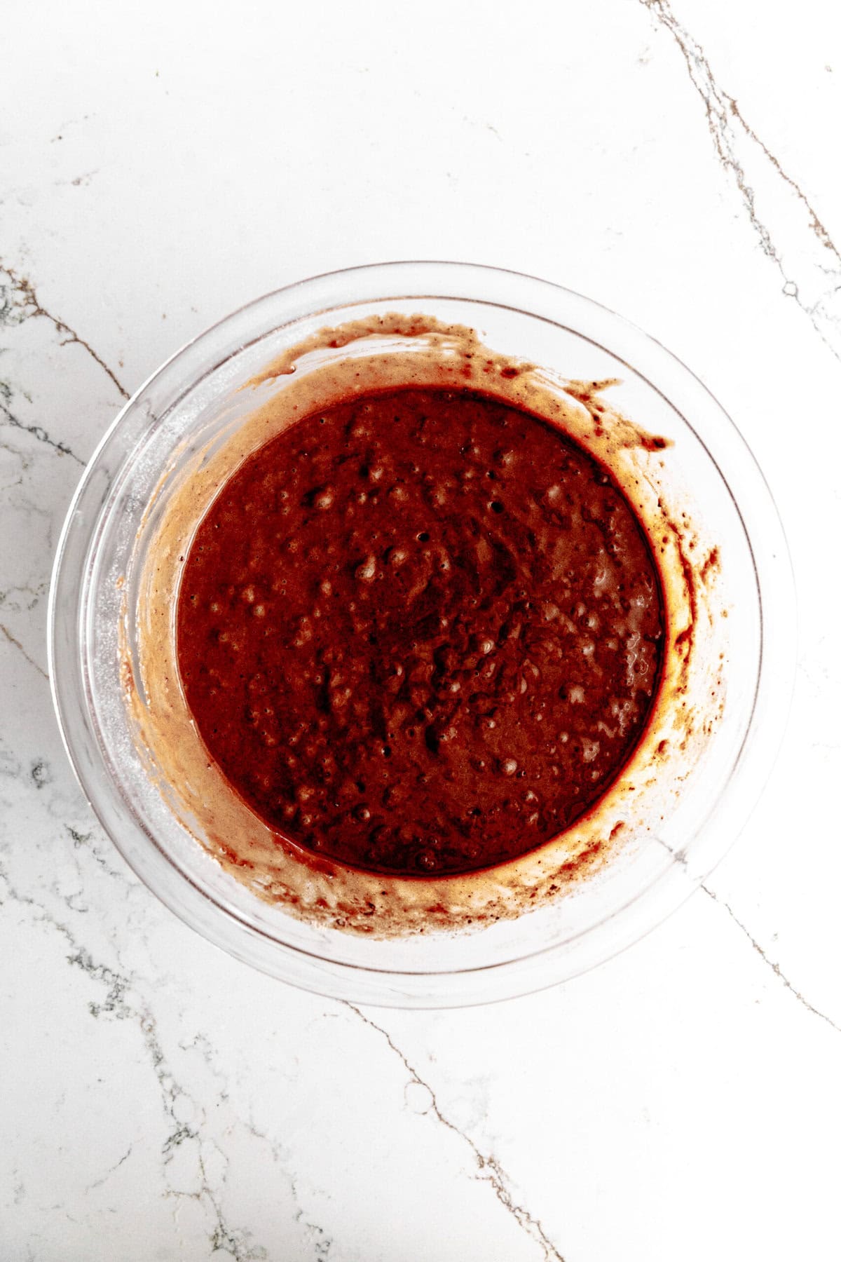 Chocolate cupcake batter in a glass bowl.