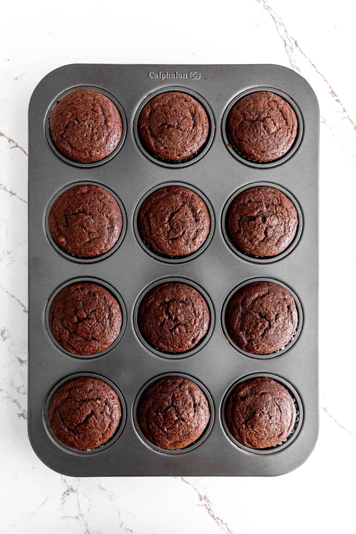 Cupcake pan filled with baked chocolate cupcakes.