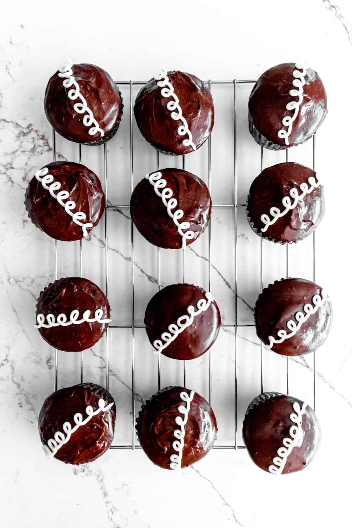 Homemade hostess cupcakes on a wire cooling rack.