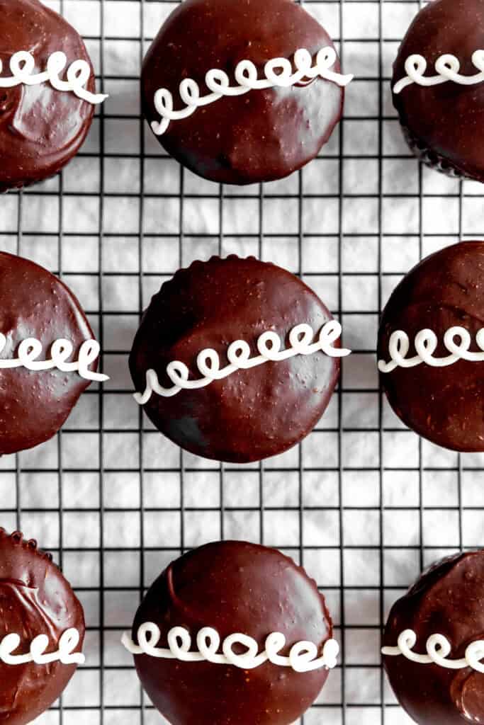 Homemade hostess cupcakes on a wire cooling rack.