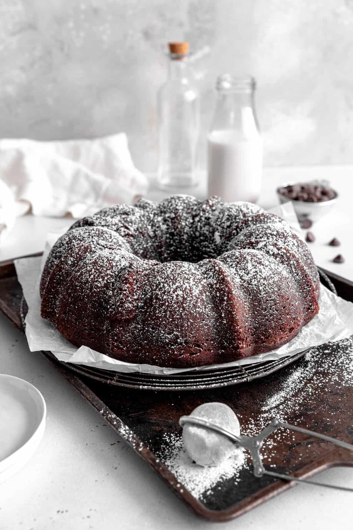 Kahlúa cake on a baking sheet dusted with powdered sugar and a jug of milk.