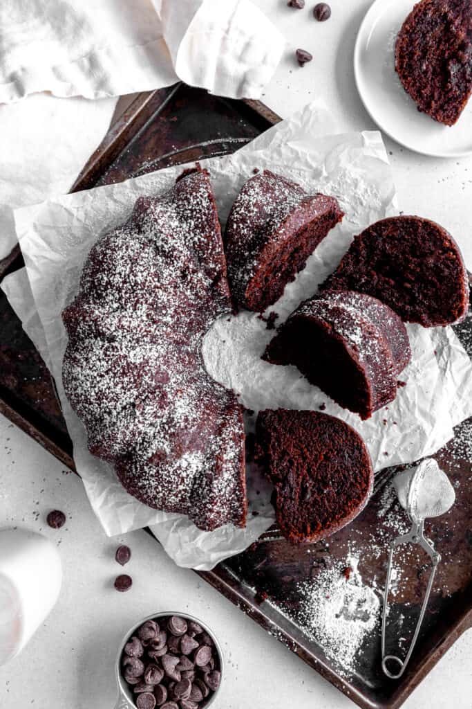 Sliced Kahlúa cake on a baking sheet, a jug of milk and a cup of chocolate chips.