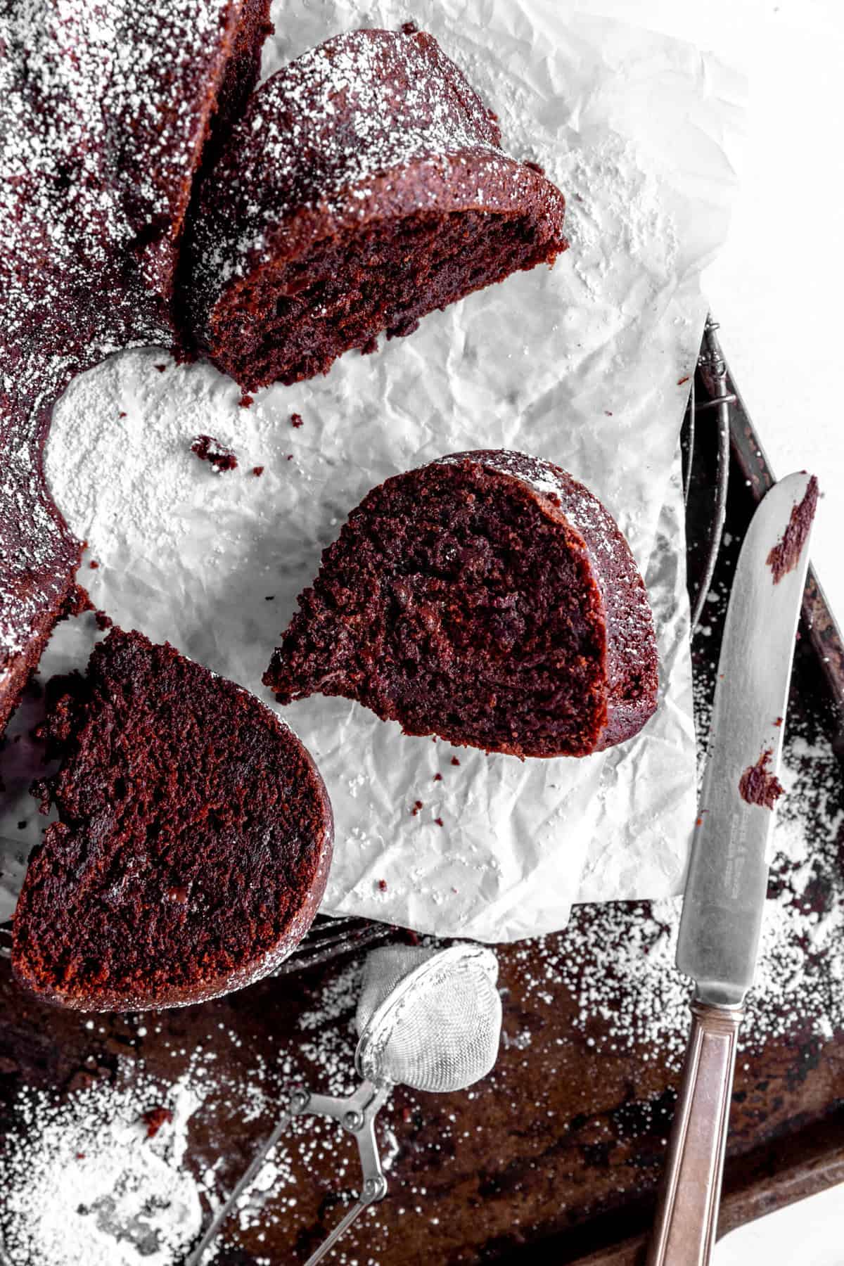 Sliced Kahlúa cake on a baking sheet with a knife.