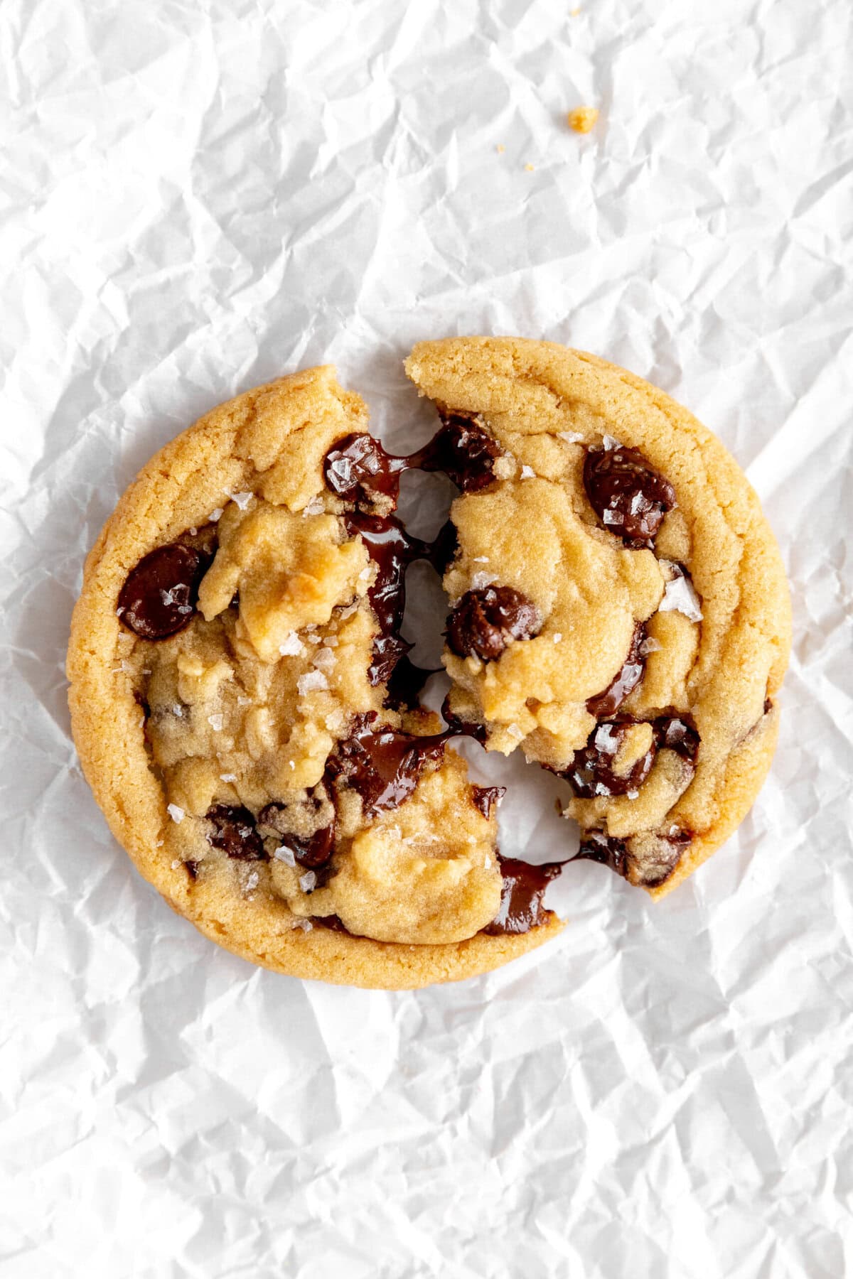 Gooey chocolate chip cookie halves being pulled apart.