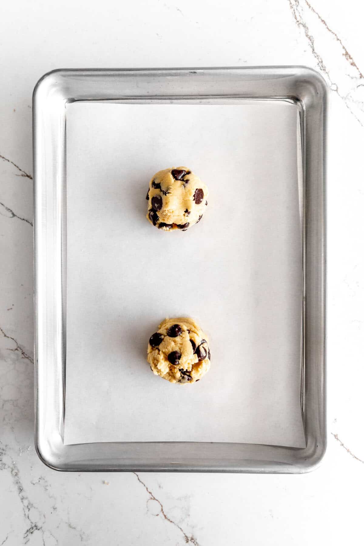 Unbaked vegan chocolate chip cookies on a small baking sheet.