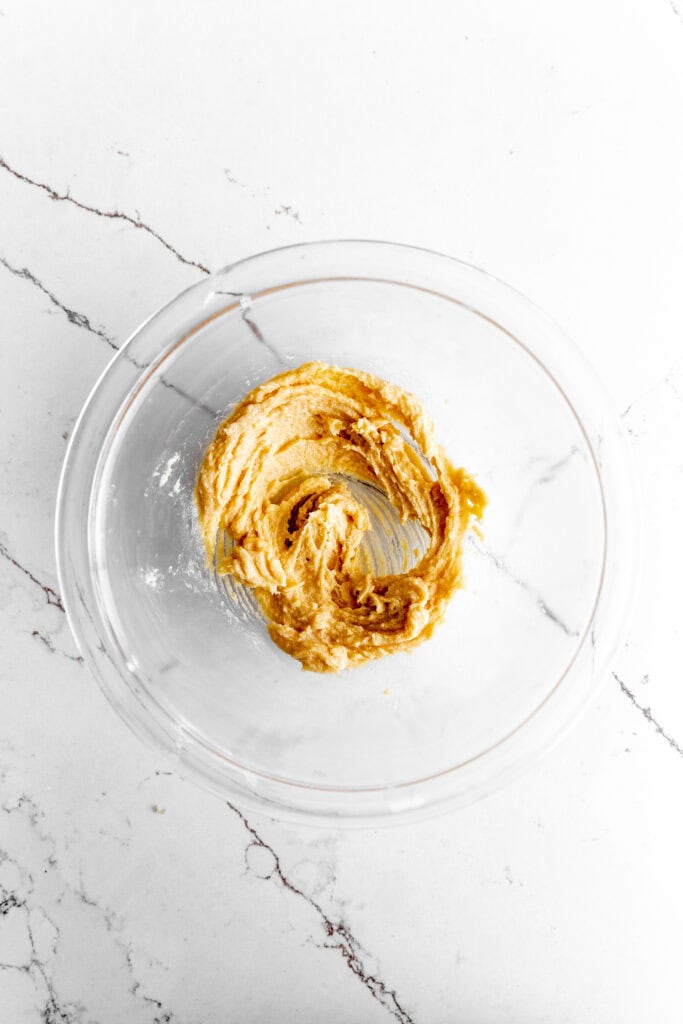 Glass bowl of mixed vegan butter and sugar.