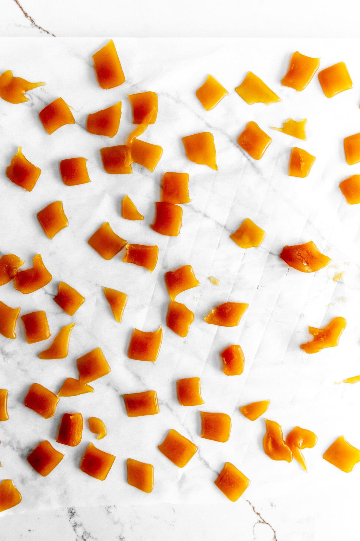 Pieces of homemade caramel on a sheet of parchment paper.