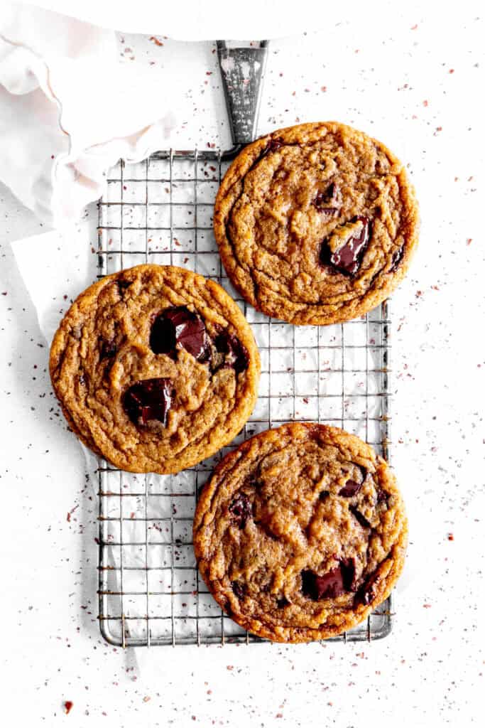 Toffee chocolate chip cookies on a wire rack and a linen napkin.