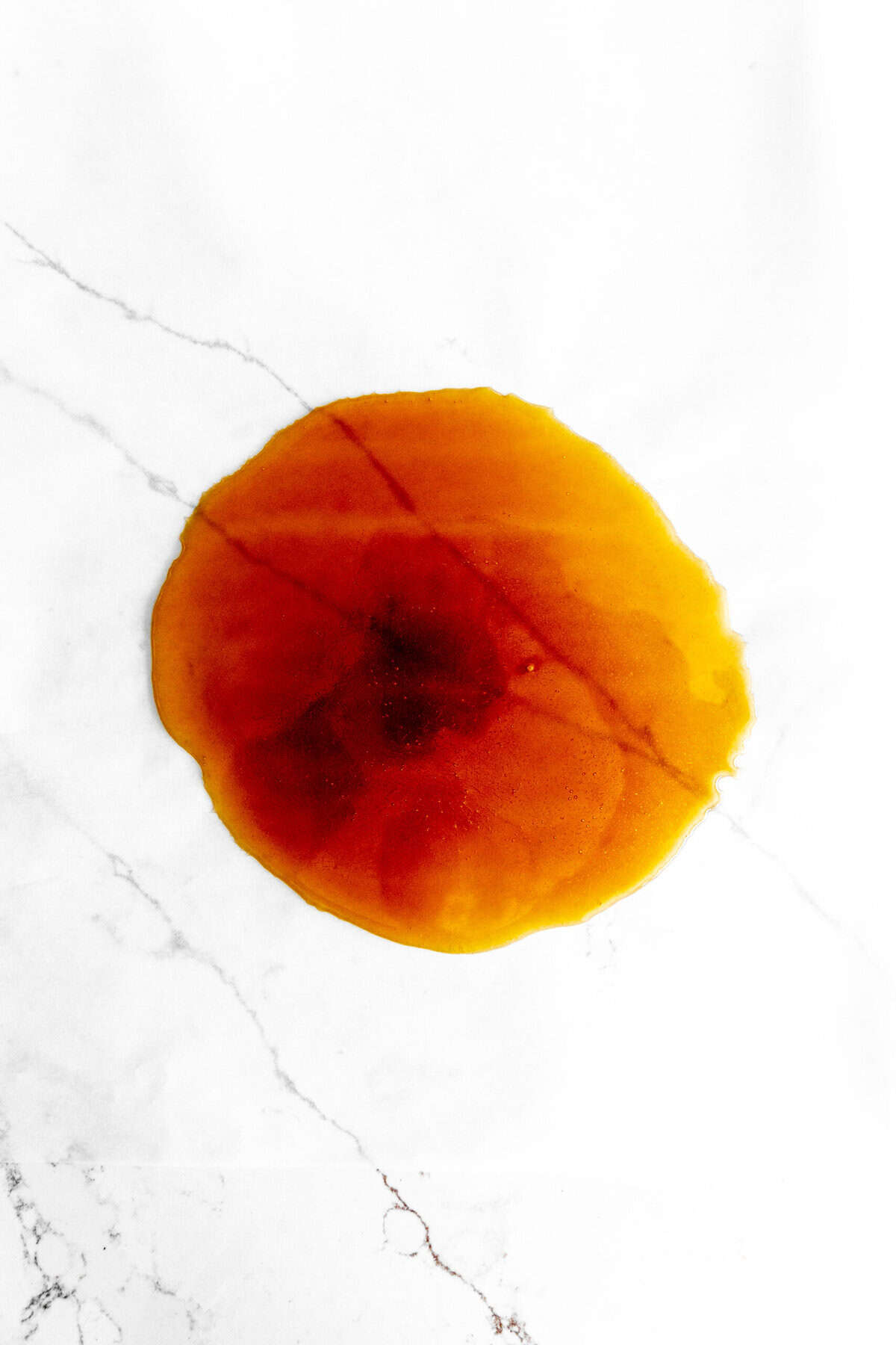 Toffee caramel poured out on a sheet of parchment paper.