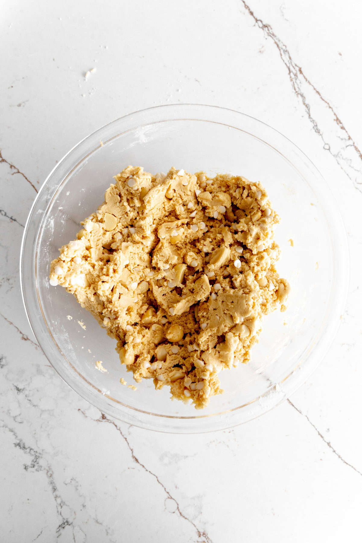 White chocolate macadamia cookie dough in a glass bowl.