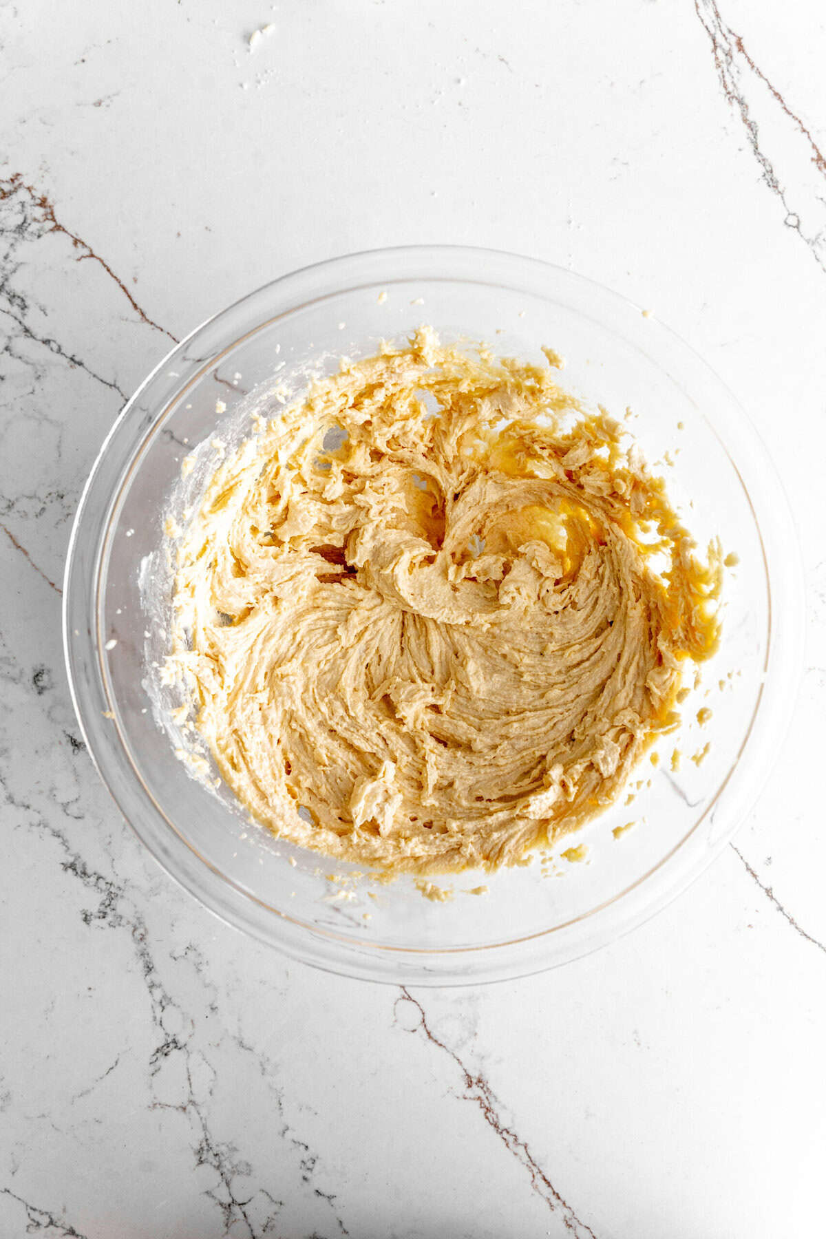 Creamed butter and sugar in a glass bowl.